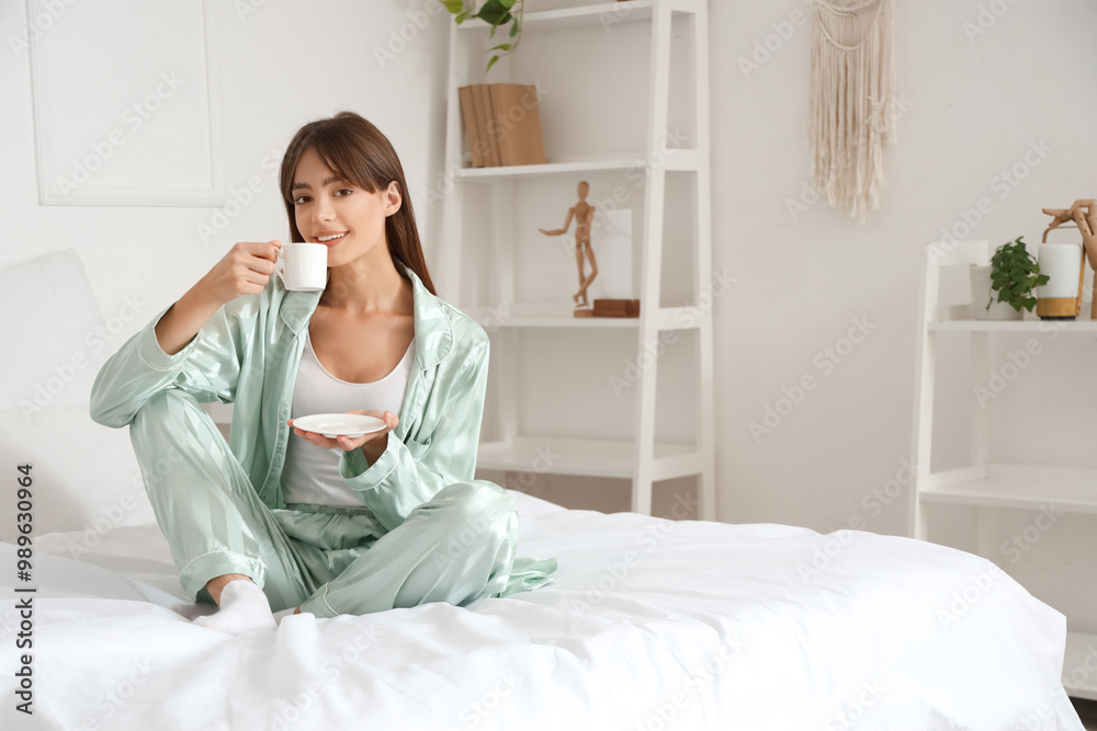 Morning of beautiful young woman with cup of coffee sitting in bedroom Morning of beautiful young woman with cup of coffee sitting in bedroom