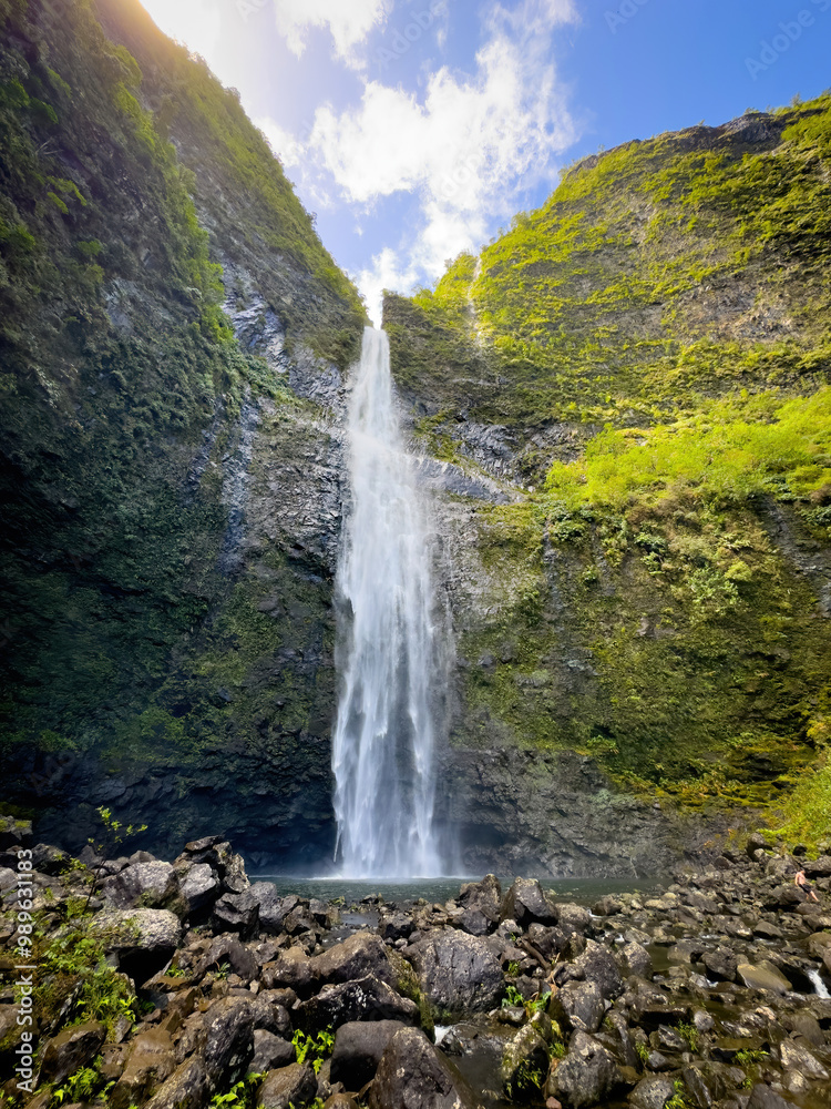 Scenic view of Hanakapiai Falls, a waterfall at the end of Hanakapiai Valley hiking trail, Kauai, Hawaii, USA against blue sky with clouds