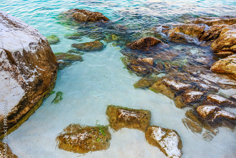 Fototapeta premium A rocky shoreline with a body of water in the background
