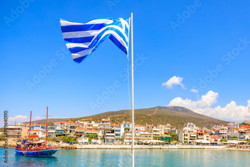 A blue and white flag is flying in the sky above a town