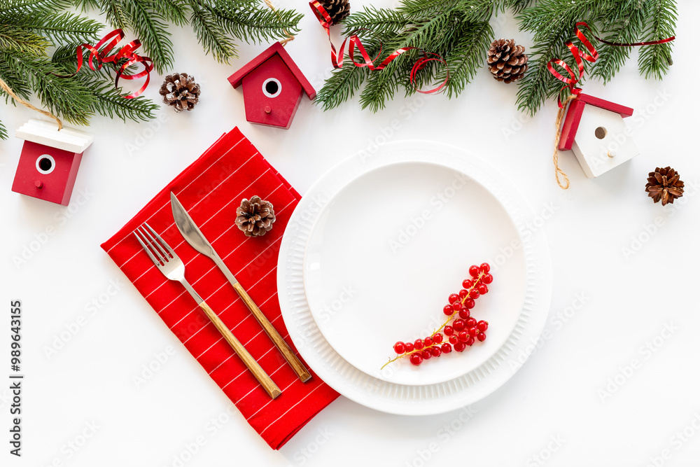 Festive table setting for Christmas and New Year Eve - plate with fir tree branch and decoration on white table, top view Festive table setting for Christmas and New Year Eve - plate with fir tree branch and decoration on white table, top view