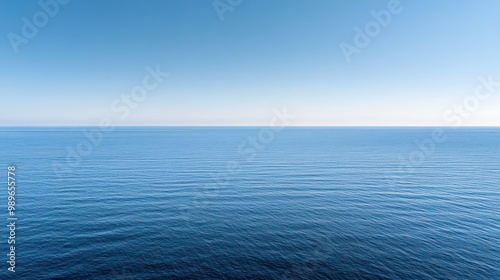 A serene view of a calm ocean under a clear blue sky, evoking tranquility and peace.