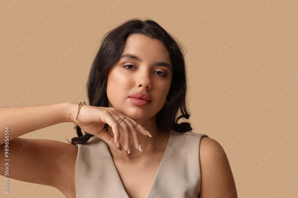 Φωτογραφία Fashionable young woman in beautiful jewelry on brown background