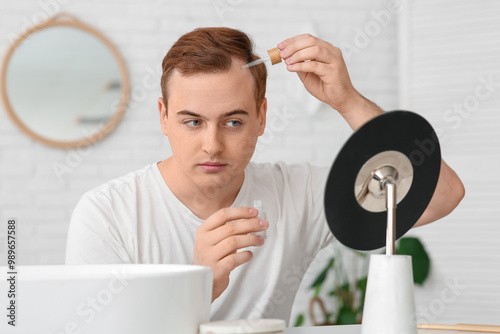 Young redhead man applying ...