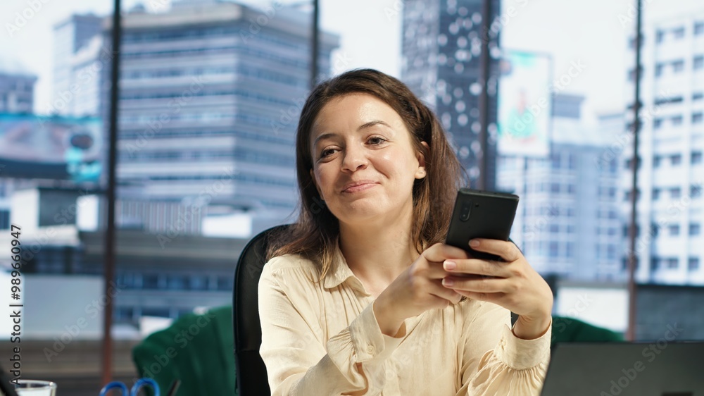 Portrait of female entrepreneur checking her personal phone messages in her CEO office, determined boss lady with a success story. Woman director feeling confident in business industry. Camera A. Portrait of female entrepreneur checking her personal phone messages in her CEO office, determined boss lady with a success story. Woman director feeling confident in business industry. Camera A.