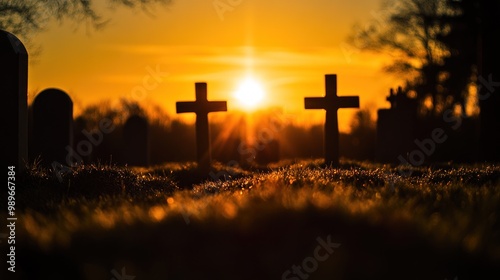 A serene sunset over a cemetery with two crosses silhouetted against the sky.
