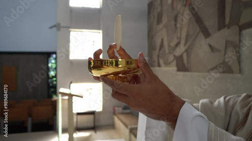 Priest in a Catholic church consecrating the host during mass.
