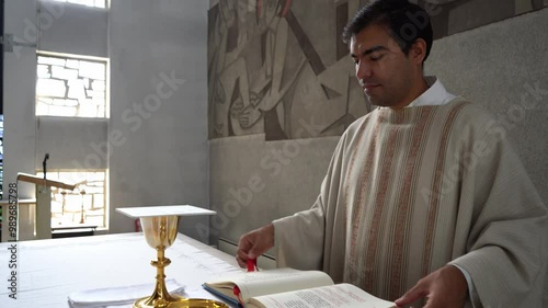 Priest leafing through missal book at mass in catholic church.