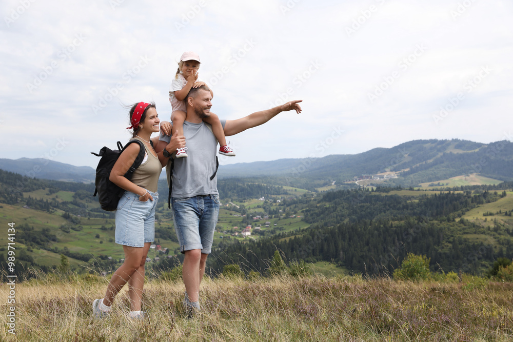 Happy family with backpacks travelling in mountains, space for text. Active tourism Happy family with backpacks travelling in mountains, space for text. Active tourism