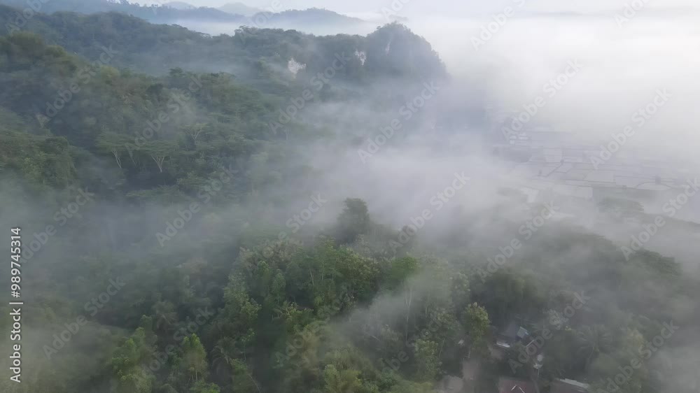 Aerial Video Misty Landscape Over Lush Green Valley at Dawn A breathtaking view of a misty landscape over a lush green valley at dawn. The foggy hills create a serene and tranquil atmosphere