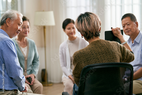 asian counselor facilitating a group discussion for senior women