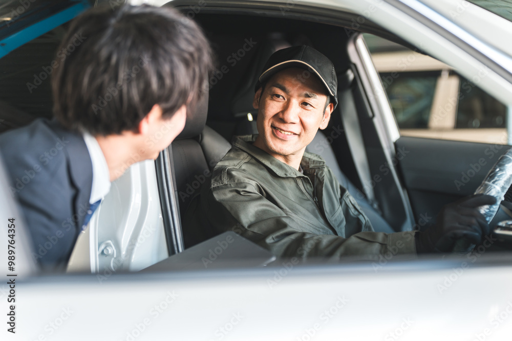 車の中でフロントマンの男性と会話する整備士の男性
車の中でフロントマンの男性と会話する整備士の男性