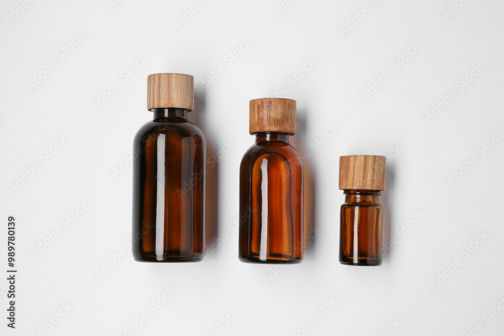 Bottles of essential oils on white background, flat lay Bottles of essential oils on white background, flat lay