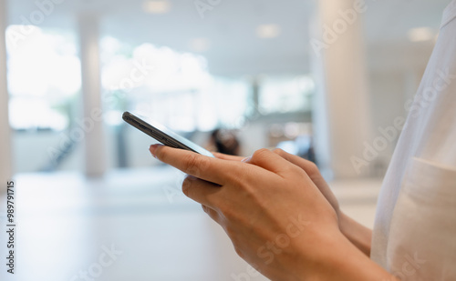 Woman's hands holding smartphone and using a social media at night street.