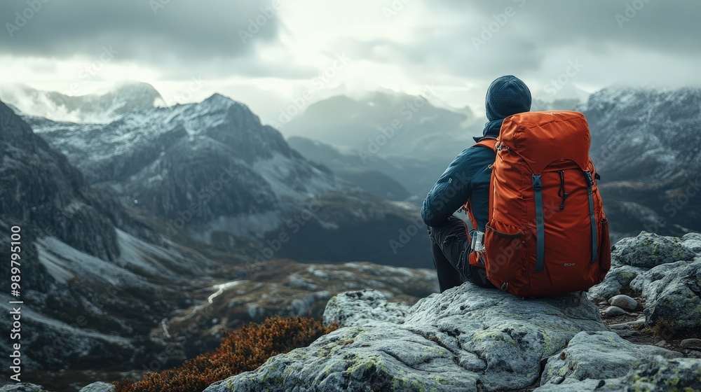 Hiker resting on a rocky outcrop, enjoying the mountain view Hiker resting on a rocky outcrop, enjoying the mountain view