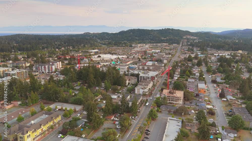 Aerial view of Langford Brtish Columbia suburban town with lush greenery and a long road stretching into the distance Aerial view of Langford Brtish Columbia suburban town with lush greenery and a long road stretching into the distance