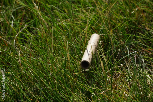 Close up of cardboard straw sitting grass
