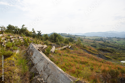 Hill landscape with storm clouds, forming tornado, dramatic weather scene, dark skies over rolling hills.