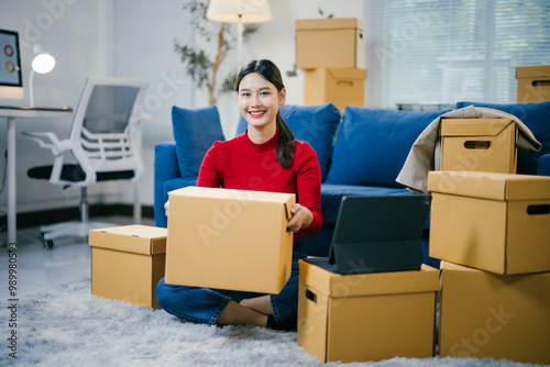 Young woman unpacks in her new home, surrounded by boxes, smiling happily as she settles in and embraces this new chapter