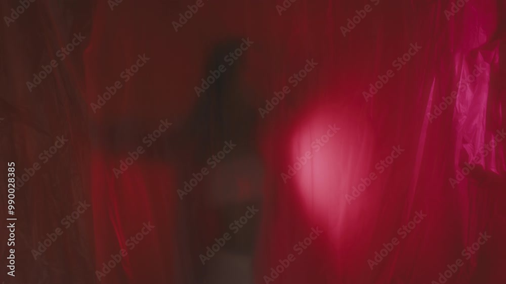 Slow shutter effect. A woman in a pink blazer is trying to get out of plastic wrap 