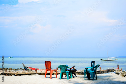 Foto Several plastic chairs with different colors and shapes are on the sand on the b