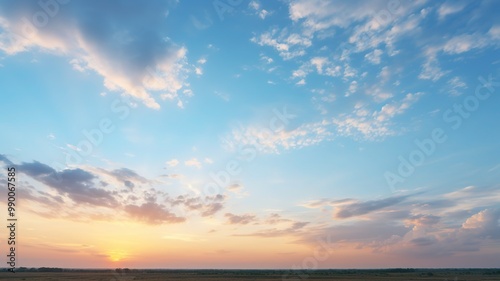 An early evening sky with scattered altostratus clouds, creating a layered, textured appearance as the sun dips below the horizon.