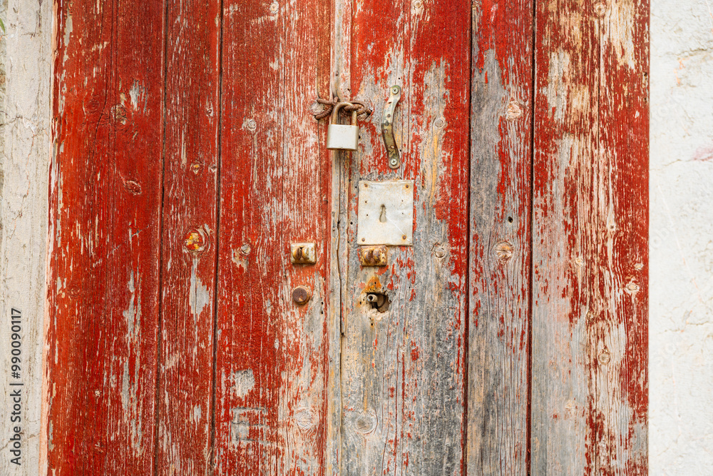 Abstract, Rustic, flaking, peeling red paint on a rotting and decaying door with rusty lock and keyhole at an abandoned house’s doorway Abstract, Rustic, flaking, peeling red paint on a rotting and decaying door with rusty lock and keyhole at an abandoned house’s doorway