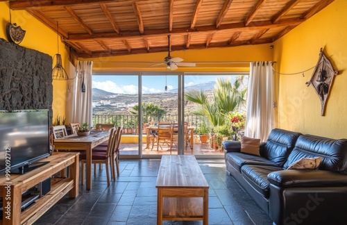 A spacious living room with large windows overlooking the city of Tenerife  in yellow walls and wooden ceiling  sofa set for relaxing after long days at sea or hiking mountains. Created with Ai