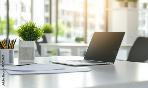 White table with a laptop in a contemporary office, document paper and pencil holder nearby, table in the middle of the room, soft natural light.