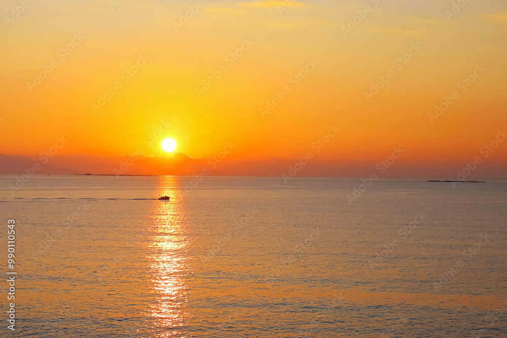 Fototapeta premium Sun setting over the calm sea