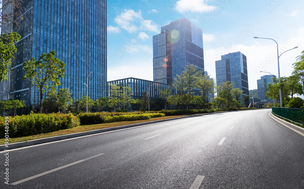 Empty asphalt road near office buildings