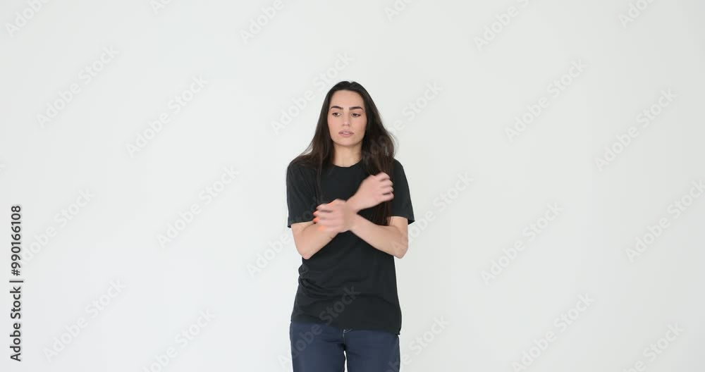 Young woman wearing casual clothes expresses anxiety touching arms on white background. Lady conveys feelings of worry and emotional distress Young woman wearing casual clothes expresses anxiety touching arms on white background. Lady conveys feelings of worry and emotional distress