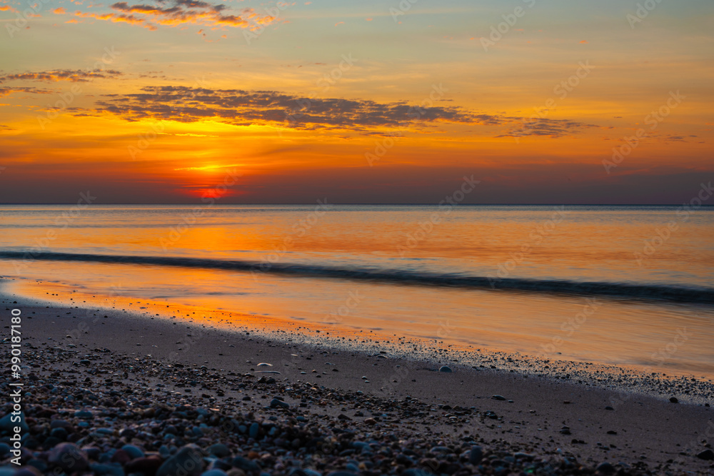 Sandy beach with pebbles of Baltic Sea on Curonian Spit at sunset. Kaliningrad region. Russia