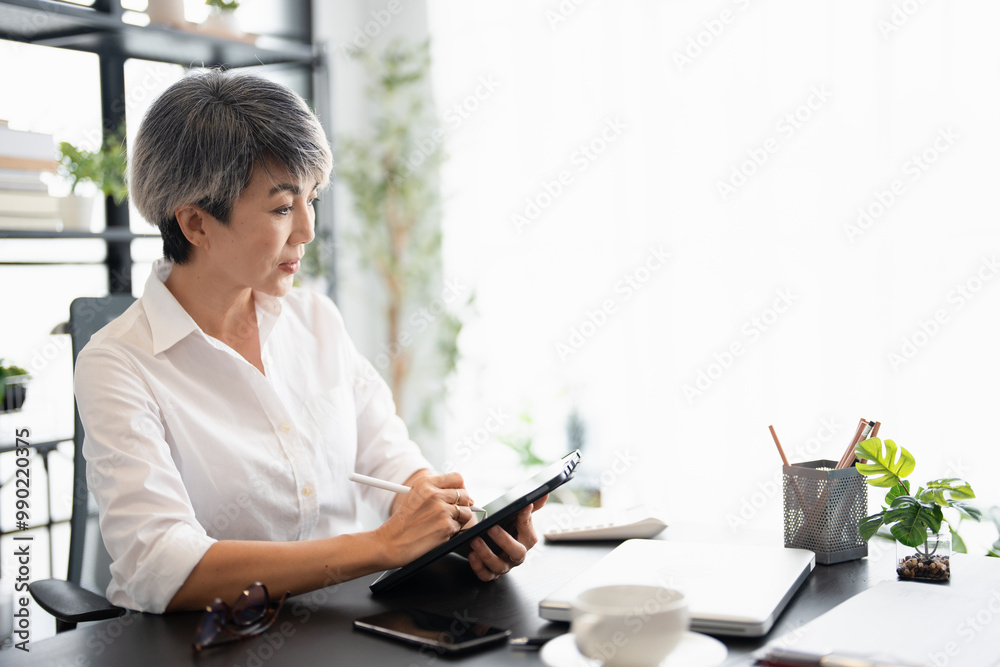 Senior confident business working woman, mentor, teacher with white short hair stand and use tablet, Portrait mature female middle aged in office discuss work Senior confident business working woman, mentor, teacher with white short hair stand and use tablet, Portrait mature female middle aged in office discuss work