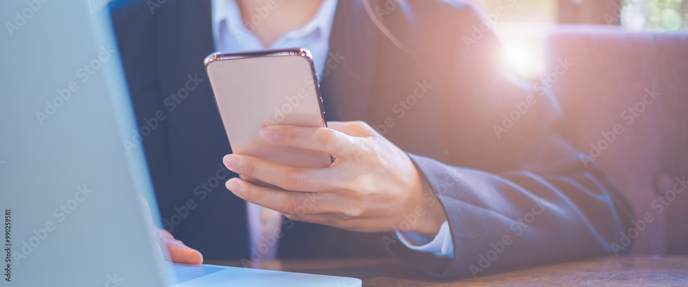 Close up,Businesswoman using mobile smart phone, working on laptop computer at office.For web banner.
