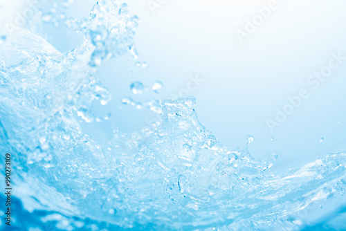 青の背景に波のように舞う水しぶき.