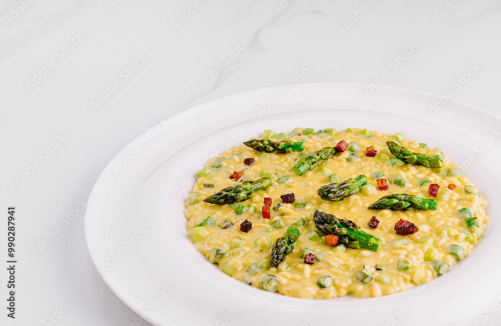 Creamy risotto with asparagus and bacon on white plate Creamy risotto with asparagus and bacon on white plate