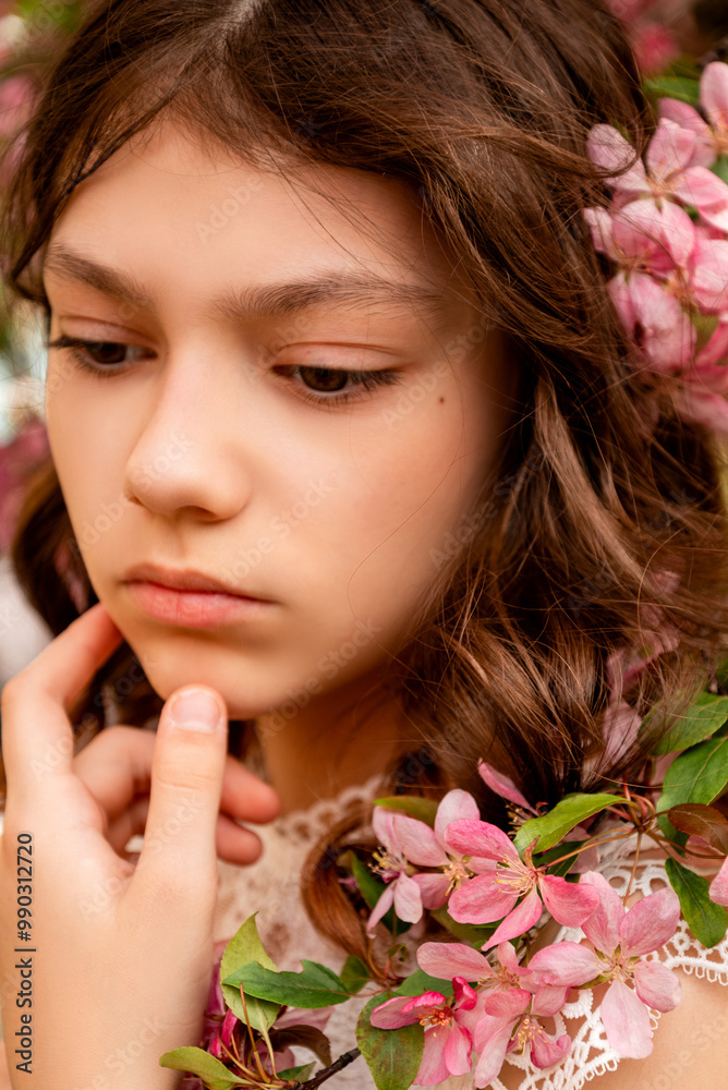 Fototapeta premium portrait of young woman with pink sakura flowers in hair