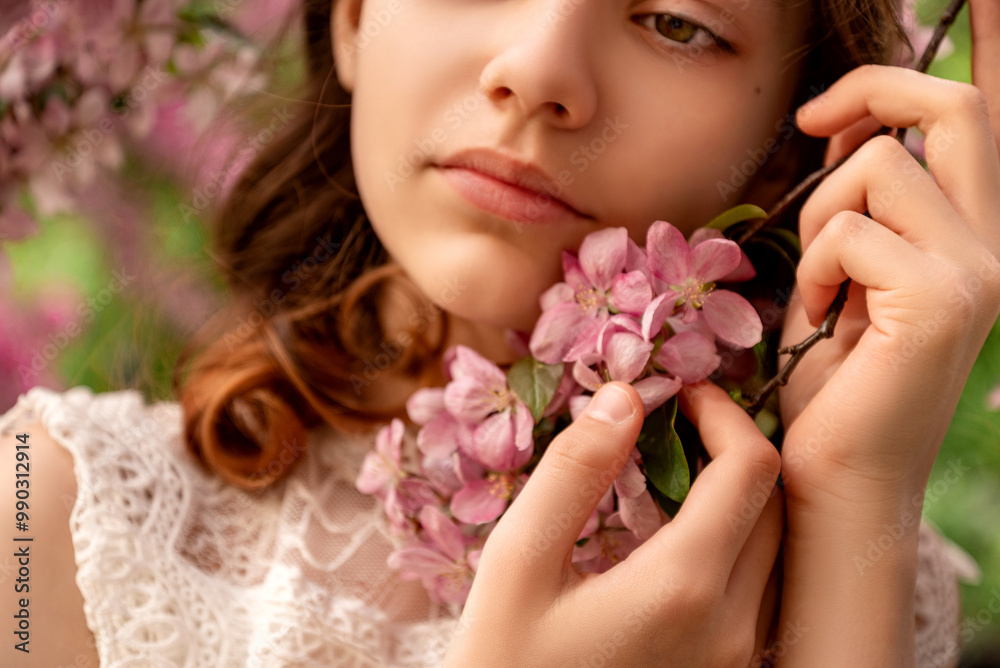 young woman holding in hand pink sakura flowers tree branch in spring orchard young woman holding in hand pink sakura flowers tree branch in spring orchard