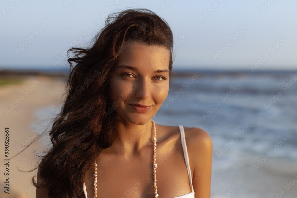 Woman in White Dress Smiling on Tropical Beach at Sunset with Ocean Waves Woman in White Dress Smiling on Tropical Beach at Sunset with Ocean Waves