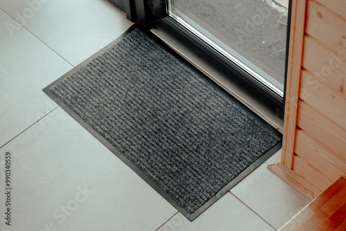 Foto A textured black doormat placed at the entrance of a contemporary home capturing