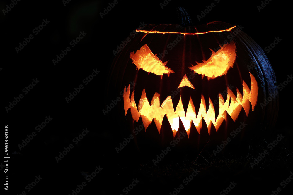 Fototapeta premium Fanged jack-o'-lantern isolated in the dark.