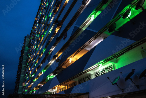 Night time view of low cost apartment exterior with decoration lights. Urban living. Vertical architecture. photo