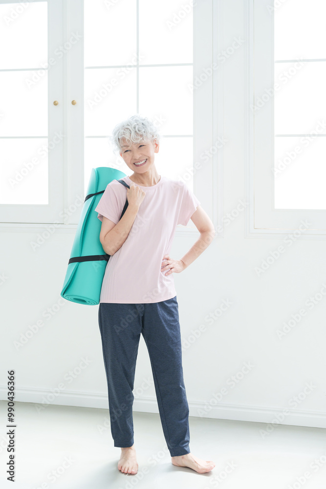 ヨガマットを持つシニア女性 ヨガマットを持つシニア女性