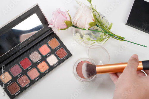 hand picked blush color with brush, with the eyeshadow palette beside it