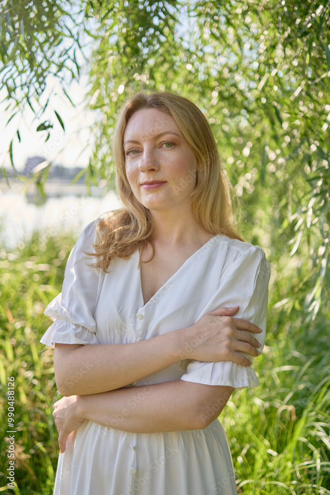 beautiful young artist in a white dress among the trees on the river bank beautiful young artist in a white dress among the trees on the river bank