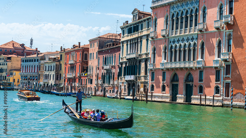 Gondole et son gondolier avec des touristes à Venise sur le grand canal et avec des vieux bâtiments colorés par une journée ensoleillée Gondole et son gondolier avec des touristes à Venise sur le grand canal et avec des vieux bâtiments colorés par une journée ensoleillée