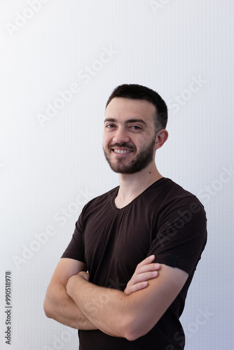 Fotografía Portrait of an young smiling man on the light gray background with a place for lettering