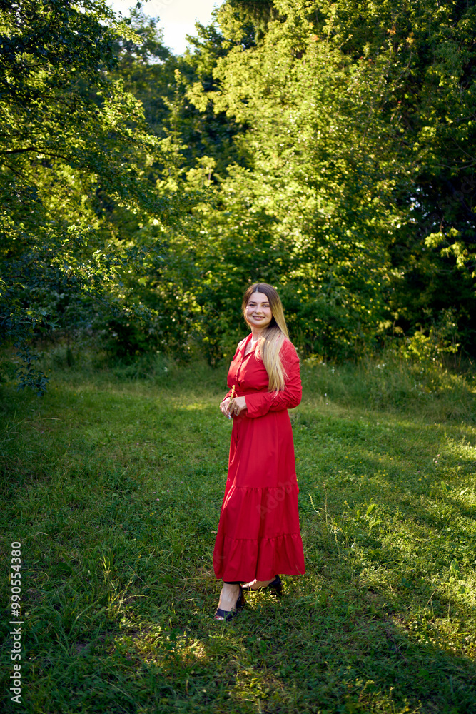portrait of a beautiful 30-year-old woman with long blond hair in a red dress in a park portrait of a beautiful 30-year-old woman with long blond hair in a red dress in a park