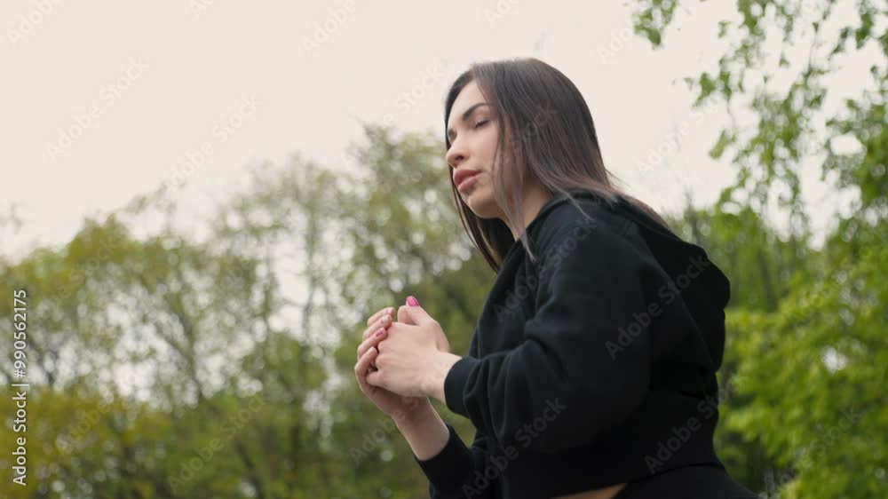A beautiful dark-haired sporty girl is doing leg exercises outdoors in the park on the stairs. slow motion A beautiful dark-haired sporty girl is doing leg exercises outdoors in the park on the stairs. slow motion